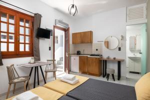 a kitchen and living room with a table and chairs at Flora Studios in Líndos