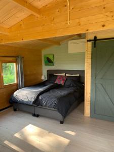 a bedroom with a bed in a wooden cabin at Fields 1216 in Zwaanshoek