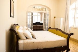 Un dormitorio con una cama con almohadas blancas. en ConSentido Tamarindo en Mérida