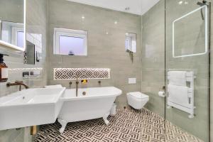a white bathroom with a tub and a toilet at Poets Apartment with Free Parking By My Getaways in Worthing