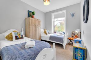 a bedroom with two beds and a window at Poets Apartment with Free Parking By My Getaways in Worthing