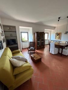 een woonkamer met een gele bank en een tafel bij Casa al Castello in Rosignano Marittimo
