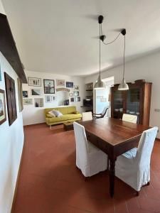 een woonkamer met een houten tafel en witte stoelen bij Casa al Castello in Rosignano Marittimo