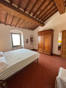 een slaapkamer met een groot bed en een raam bij Casa al Castello in Rosignano Marittimo