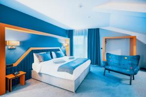 um quarto azul com uma cama e uma cadeira em Roof 264 Hotel & Suites em Sakarya