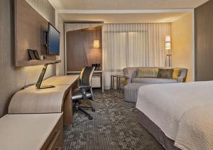 a hotel room with two beds and a desk at Courtyard by Marriott Battle Creek in Battle Creek
