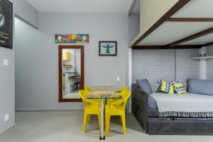 een slaapkamer met een bed, een tafel en gele stoelen bij Copa Sky Apartments in Rio de Janeiro