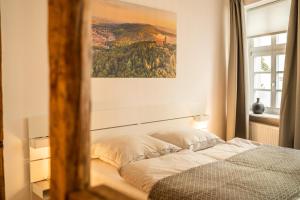 a bed in a bedroom with a painting on the wall at Klein aber Fein in Weinheim