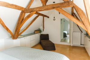 1 dormitorio con paredes blancas y vigas de madera en Bijgebouw hoeve in landelijke omgeving, en Putte