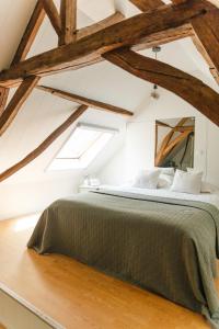 Schlafzimmer mit einem großen Bett mit Holzbalken in der Unterkunft Bijgebouw hoeve in landelijke omgeving in Putte