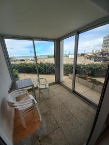 a balcony with a table and a bench and a view of the beach at Appartement T3 - 4 personnes - Face Océan - Thalasso in Pornichet