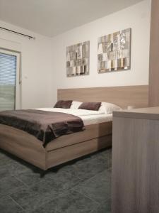 a bedroom with a bed and two pictures on the wall at Apartments Simona in Lopar
