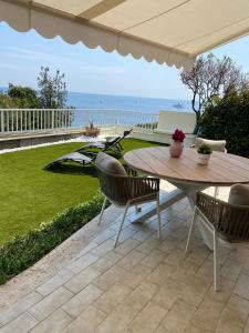 a patio with a table and chairs and the ocean at Cap d.Azur in Roquebrune-Cap-Martin