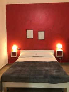 カステッランマーレ・デル・ゴルフォにあるCasa Tizianaの赤い壁のベッドルーム1室(ベッド1台、照明2つ付)