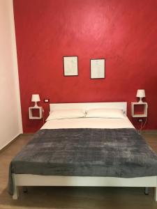 カステッランマーレ・デル・ゴルフォにあるCasa Tizianaの赤い壁のベッドルーム1室(白いベッド1台付)