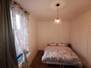 een kleine slaapkamer met een bed en een raam bij La halte cycliste in Domfront