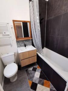 a bathroom with a toilet and a sink and a tub at La halte cycliste in Domfront