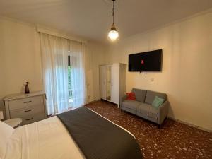 フラスカーティにあるGalleria Frascati Rooms and Apartmentのベッドルーム(ベッド1台、ソファ、テレビ付)