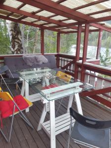 a glass table and chairs on a wooden deck at Holiday Raustua Cabin in Gol