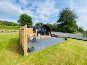 a gazebo with a table and chairs in a yard at Cleugh Lodge in Lockerbie