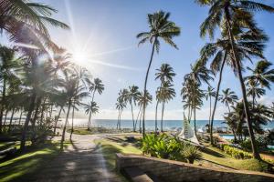 a pathway to the beach with palm trees and the ocean at Catussaba Resort Hotel in Salvador
