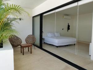 a bedroom with a bed and a glass wall at Loft con alberca en Telchac in Telchac Puerto