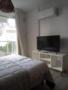 1 dormitorio con 1 cama y TV de pantalla plana en Paraguay Curt en Rosario