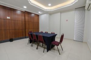 una sala de conferencias con mesa negra y sillas rojas en Hotel Caiuá Express Umuarama en Umuarama