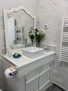 a white bathroom with a sink and a mirror at Ocean Garden, 4 units by the ocean in São Vicente