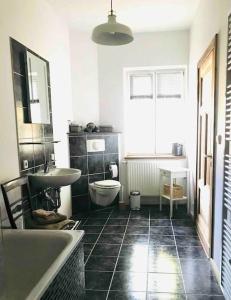 a bathroom with a tub and a toilet and a sink at Ferienwohnung in Schmargendorf bei Angermünde in Angermünde