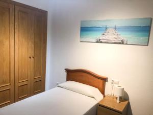 1 dormitorio con 1 cama y una foto en la pared en Piso en Teatino Feria, en Málaga
