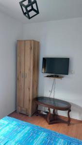 Habitación con mesa, TV y armario. en Guest House Vodica, en Virpazar