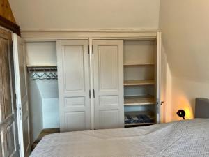 1 dormitorio con armarios blancos y 1 cama. en Schaapskooi 20, en Dwingeloo