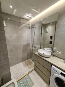 a bathroom with a shower and a sink and a toilet at Comfort Apartment Tirana Center in Tirana