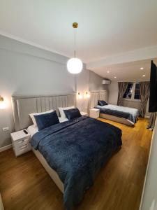 a bedroom with two beds and a large blue blanket at Comfort Apartment Tirana Center in Tirana