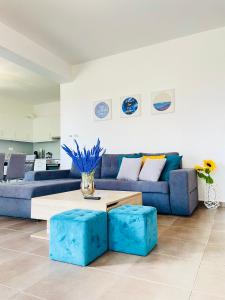 uma sala de estar com um sofá azul e uma mesa em Epidavros View em Ancient Epidavros