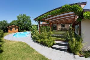 a backyard with a pool and a pergola at Villa Centre Alsace in Sélestat