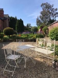 een paar stoelen en een tafel in een tuin bij The Coach House at Copper Hall in Leominster