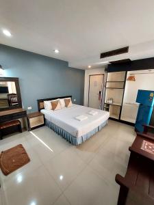 duża sypialnia z dużym łóżkiem i pianinem w obiekcie Traveller Inn Hotel w mieście Chiang Mai