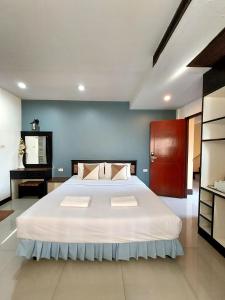 sypialnia z dużym białym łóżkiem z niebieską ścianą w obiekcie Traveller Inn Hotel w mieście Chiang Mai