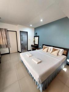 sypialnia z dużym łóżkiem z niebieską ścianą w obiekcie Traveller Inn Hotel w mieście Chiang Mai
