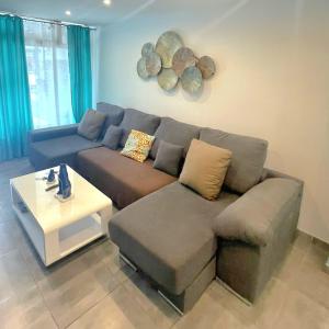 ein Wohnzimmer mit einem Sofa und einem Tisch in der Unterkunft Luxurious Duplex Trinidad in Puerto Rico de Gran Canaria