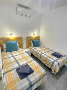 dos camas sentadas una al lado de la otra en una habitación en Luxurious Duplex Trinidad en Puerto Rico