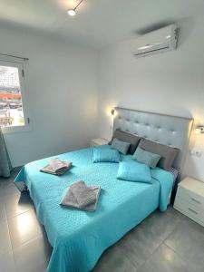 ein Schlafzimmer mit einem blauen Bett mit zwei Handtüchern darauf in der Unterkunft Luxurious Duplex Trinidad in Puerto Rico de Gran Canaria
