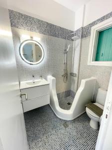 a bathroom with a sink and a toilet and a mirror at Twins Apartments in Fanari