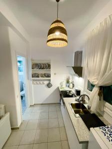 a kitchen with a sink and a pendant light at Twins Apartments in Fanari