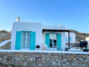 Casa azul y blanca con pared de piedra en Twins Apartments, en Fanari