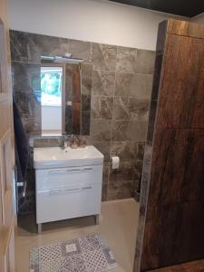 ein Bad mit einem Waschbecken und einem Spiegel in der Unterkunft Apartmány Domaša Poľany in Holčíkovce