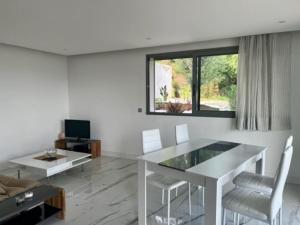 een woonkamer met een witte tafel en stoelen bij Les Mimosas in Mandelieu-la-Napoule