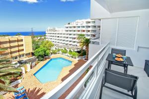 a balcony with a view of the pool and the ocean at Buena Vista Ponderosa 517 in Playa Fañabe